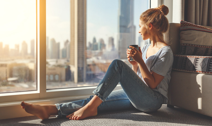 Woman sitting in window drinking coffee